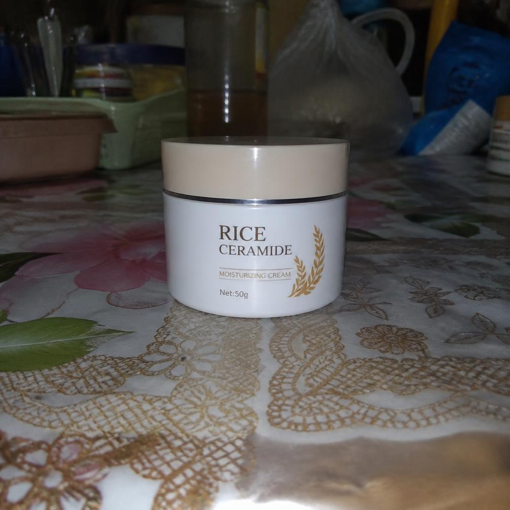 Foto amadora de um pote de creme tirada com celular em uma mesa bagunçada